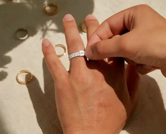 Diamond ring being placed on a finger.