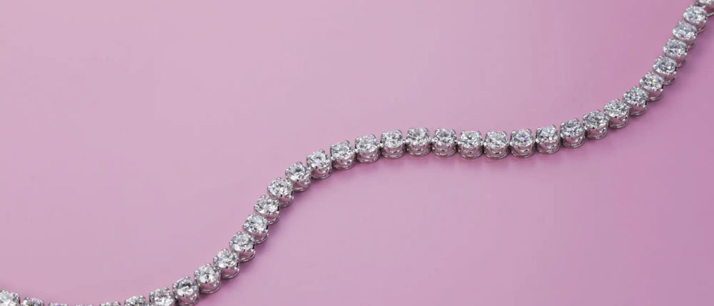 A sparkling diamond tennis necklace with a continuous line of round-cut stones set in a sleek, silver-toned metal band.