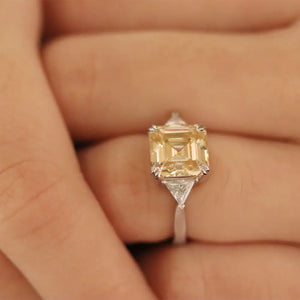 Stefani Asscher in Canary Yellow Moissanite with Trilliant Side Stones Trilogy Ring in 18K gold - LeCaine Gems