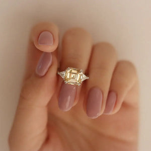 Stefani Asscher in Canary Yellow Moissanite with Trilliant Side Stones Trilogy Ring in 18K gold - LeCaine Gems